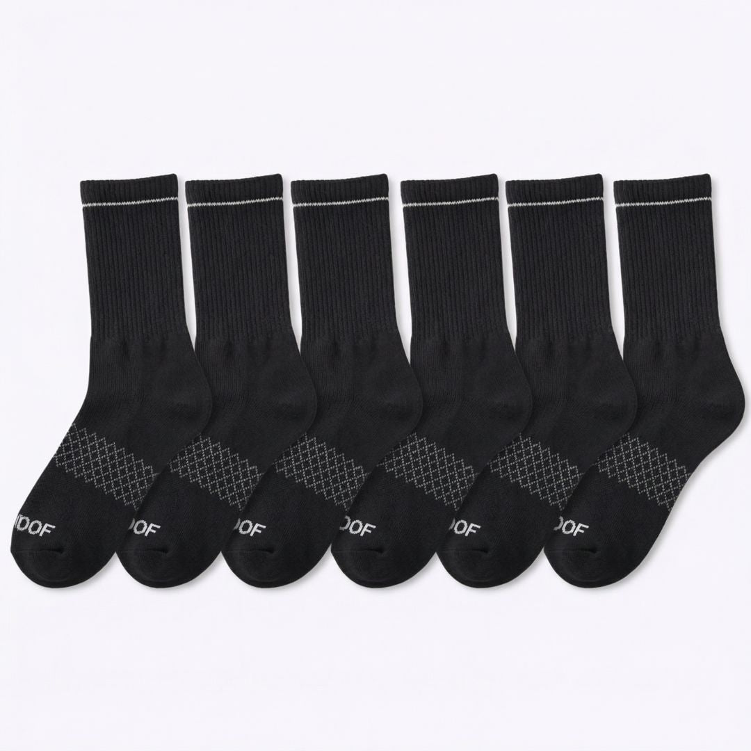 Flat lay display of a six-pair bundle of solid black crew-cut compression socks with white trim details.