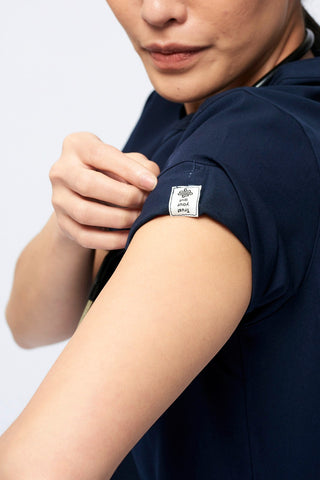 Nurse wearing a Dr. Woof Women's Short Sleeve Henley Scrub Top